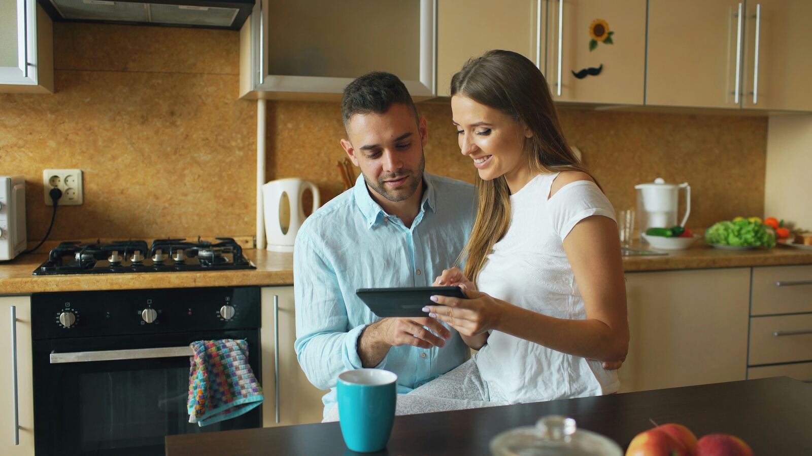 Energy assessor reviewing a tablet with a homeowner in their kitchen during a home energy assessment.