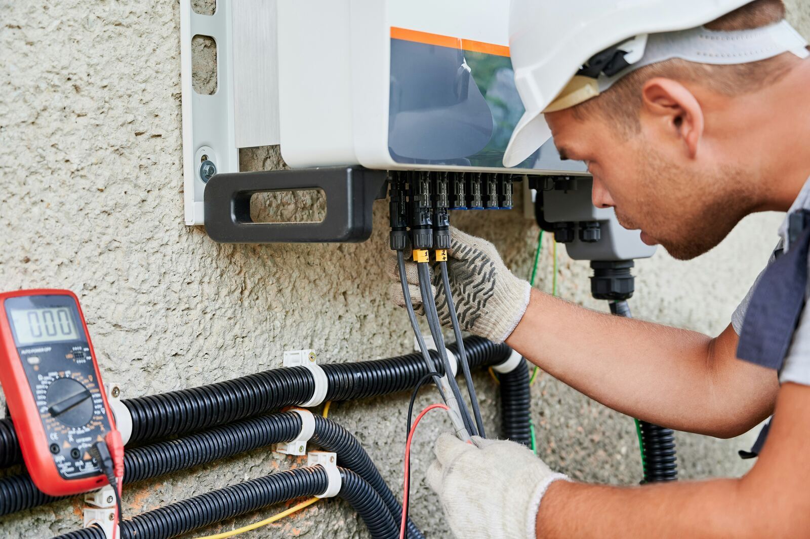 Engineers installing an air source heat pump outside a modern home.